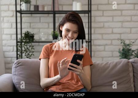 Happy young caucasian woman using mobile phone at home. Stock Photo