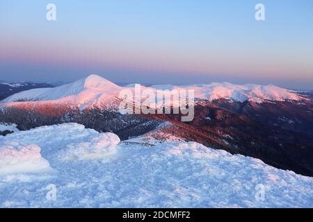 Fantastic sunrise illuminates the mountain. Cold winter morning. Amazing sky with clouds. Wallpaper background. Location place Carpathian, Ukraine, Eu Stock Photo