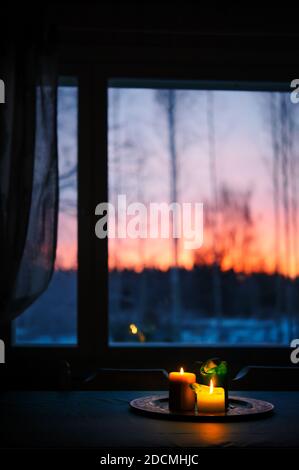 Candles on the table, sunset sky in the background. Stock Photo
