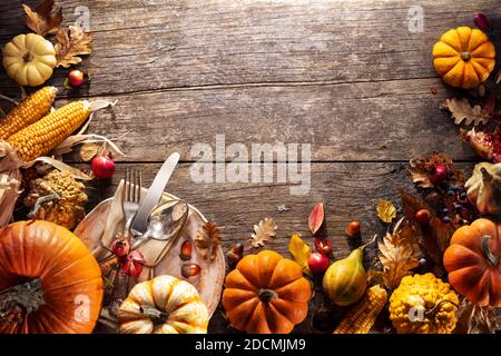 Thanksgiving Board - Table Setting With Silverware And Pumpkins On Aged Wooden Plank Stock Photo