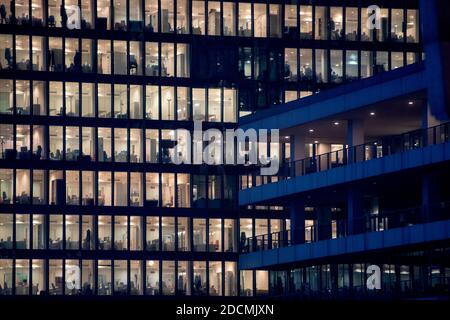 office building facade - business people working at night Stock Photo