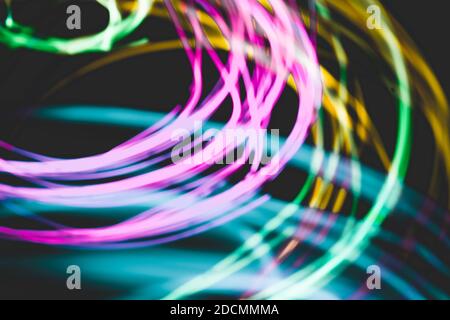 Abstract modern digital background. Pink, green, cyan, and yellow light circle motion in darkness Stock Photo