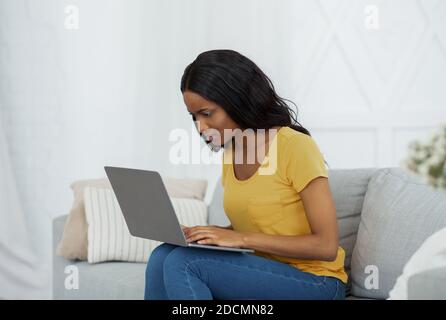 Pensive black student having difficulty passing exam or making online task on laptop at home Stock Photo