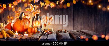 Thanksgiving - Old Table With Pumpkins And Corns With Bokeh Lights In Dark Background Stock Photo