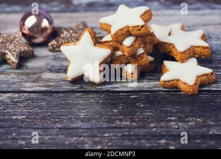 christmas background for greeting cards with copy space, cinnamon stars beside a christmas ball on wooden background Stock Photo