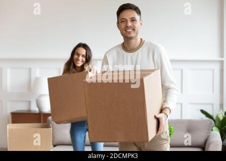 Couple holding cardboard boxes relocating to new home Stock Photo
