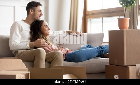 Couple resting on couch on moving day to new home Stock Photo