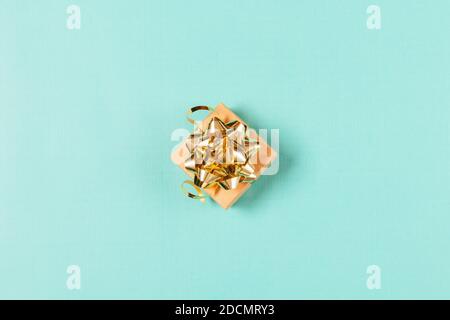 Top view gift box with gold bow and ribbons on light blue background. Stock Photo