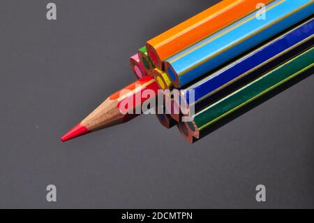 metaphor of strategy and teamwork shown by color pencils on black background, representing the concept of thinking outside the box. Stock Photo