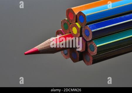 metaphor of strategy and teamwork shown by color pencils on black background, representing the concept of thinking outside the box. Stock Photo