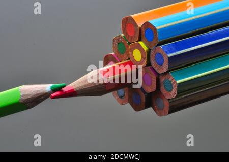 metaphor of strategy and teamwork shown by color pencils on black background, representing the concept of thinking outside the box. Stock Photo