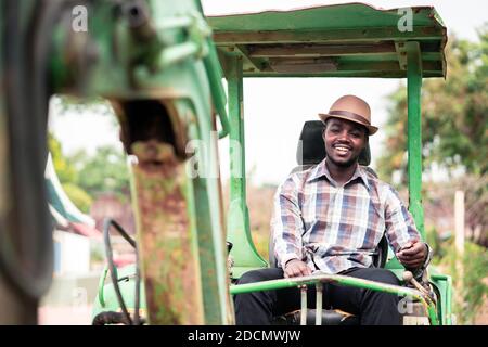 African worker driving heavy construction equipment backhoe with smile and happy Stock Photo