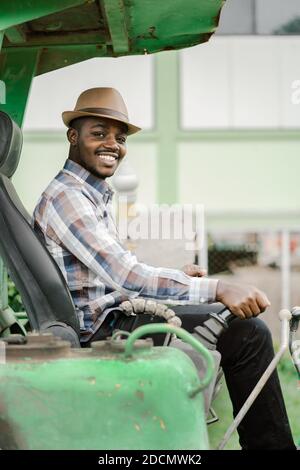 African worker driving heavy construction equipment backhoe with smile and happy Stock Photo