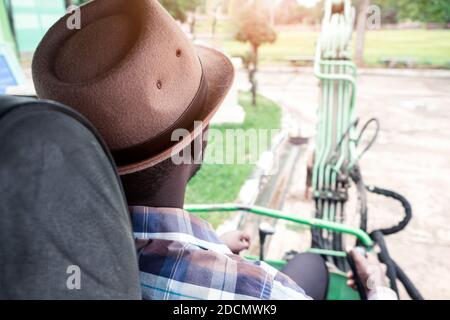 African worker driving heavy construction equipment backhoe Stock Photo
