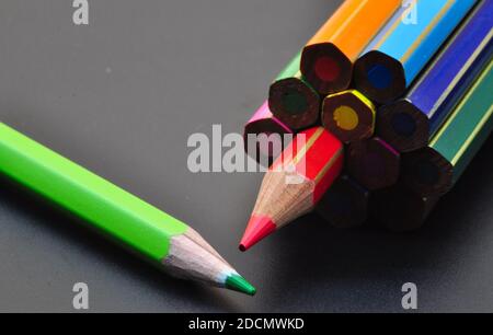 metaphor of strategy and teamwork shown by color pencils on black background, representing the concept of thinking outside the box. Stock Photo