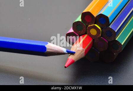 metaphor of strategy and teamwork shown by color pencils on black background, representing the concept of thinking outside the box. Stock Photo