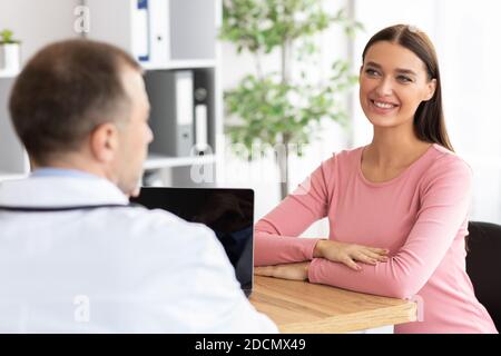 Male experienced gynecologist talking to his patient Stock Photo
