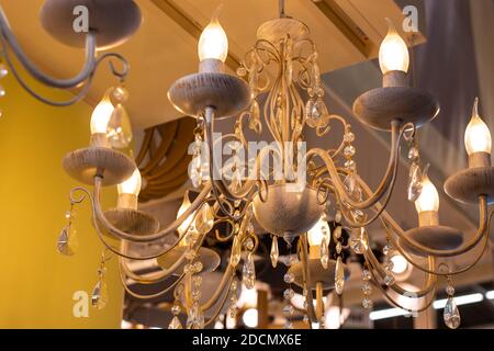 beautiful chandelier with candle-shaped bulbs and crystal drops, room lighting and decor. Stock Photo