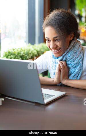 Happy smiling African American young woman talking online with her friends or relatives. Stock Photo