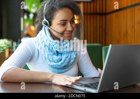 Smiling African American young woman in front of a laptop monitor while talking online. Online education concept. Stock Photo