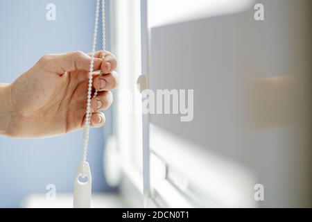 Man testing cassette roller blinds on windows Stock Photo