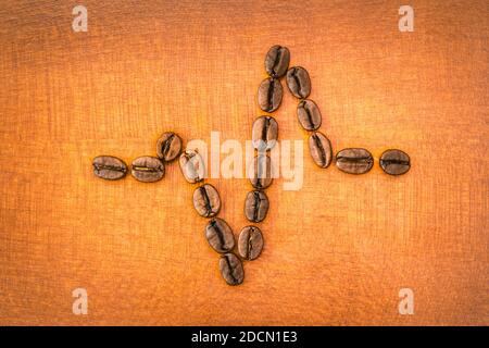 Roasted coffee beans forming a heartbeat lifeline on wood symbolizing vitality and energy in life Stock Photo