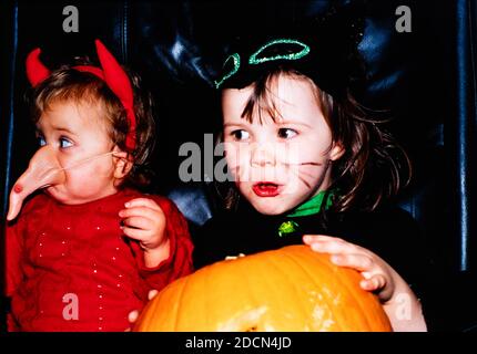 Two children dressed for Halloween with a pumpkin, UK Stock Photo