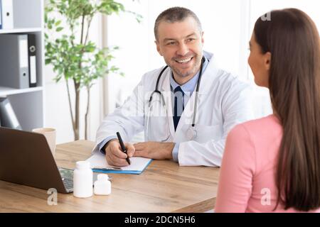 Male experienced doctor talking to his female patient Stock Photo