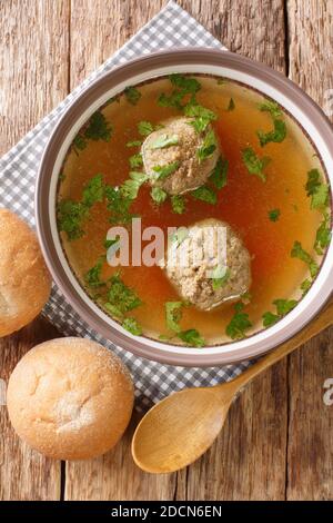 Leberknodelsuppe German liver dumpling soup close-up in a plate on the table. Vertical top view from above Stock Photo