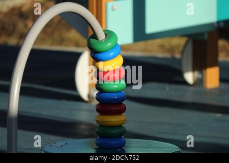 Abacus of colors of the rainbow on the playground on a sunny day. Children's wooden or plastic multi-colored estimates for the outdoors. Stock Photo