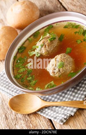 Leberknodelsuppe German liver dumpling soup close-up in a plate on the table. Vertical Stock Photo
