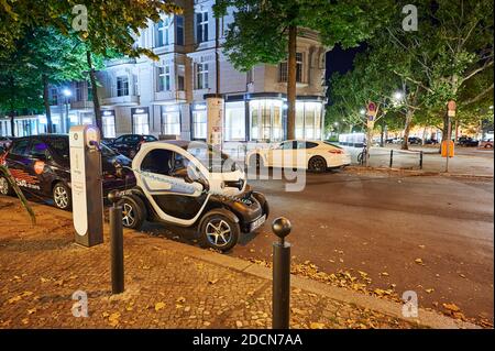 Berlin, Germany - August 16, 2020: View to an electric car that is being charged at a public charging station at night. Stock Photo