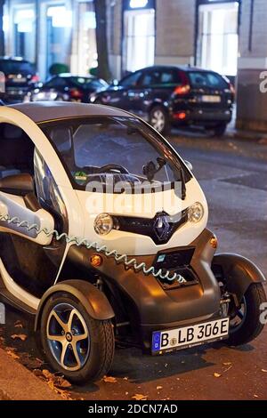 Berlin, Germany - August 16, 2020: View to an electric car that is being charged at a public charging station at night. Stock Photo