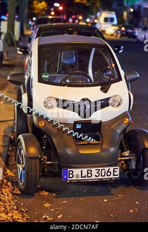 Berlin, Germany - August 16, 2020: View to an electric car that is being charged at a public charging station at night. Stock Photo