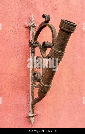 antique looking rusty flagpole holder on the house wall Stock Photo