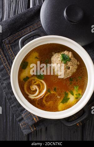 Rindsuppe Brown Beef Soup Recipe close-up in a saucepan on the table. Vertical top view from above Stock Photo