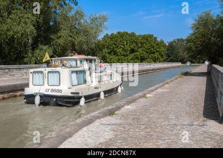 Motorboat crossing the Pont-canal de l'Orb (bridge) over the Orb River,  along the Canal du Midi at the town of Beziers, Languedoc-Roussillon,France Stock Photo