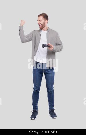 Man Standing with Joystock in Hand Isolated. Man Happy with Game. Man Cheering. Stock Photo