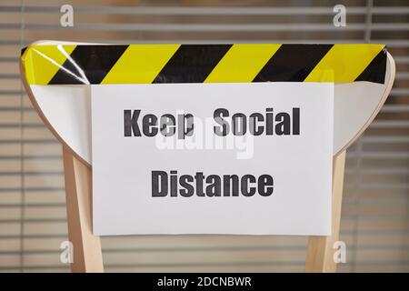 Background image of chair for waiting in line in office with Keep Social Distance sign, copy space Stock Photo