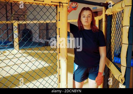 Female MMA fighter in bandages poses in gym Stock Photo