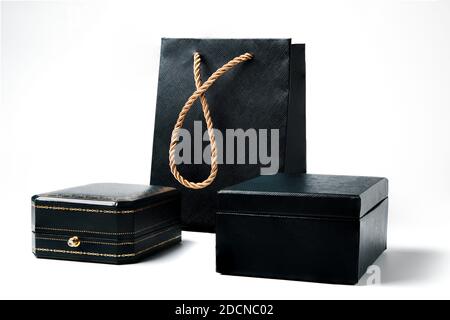 Black gift boxes with golden decoration and gift bag with golden strap isolated Stock Photo
