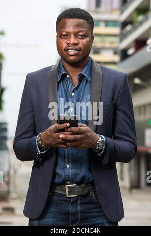 Man in business suit is enjoying modern mobile technologies in city.Concept of modern technologies order by phone. Stock Photo