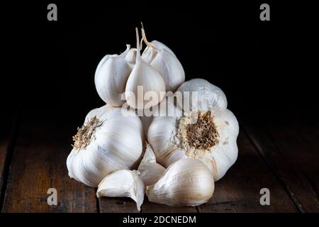 Some garlic bulbs and cloves  on the kitchen table for cooking Stock Photo