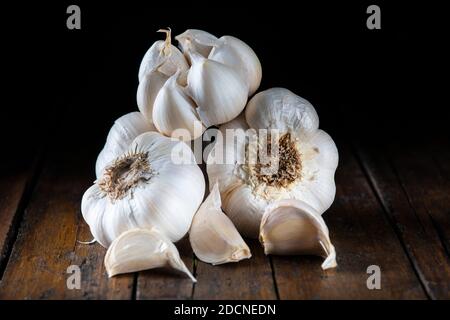 Some garlic bulbs and cloves  on the kitchen table for cooking Stock Photo