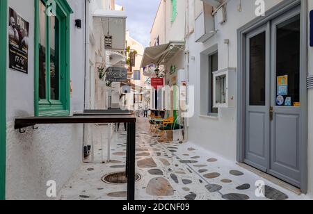 Tinos / Greece - October 17 2020: Whitewashed houses and cobblestone alley in Chora of Tinos, a Greek island situated in the Aegean Sea. Stock Photo