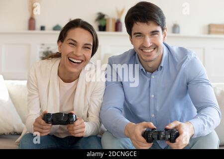 Overjoyed young couple playing video game on console at home Stock Photo