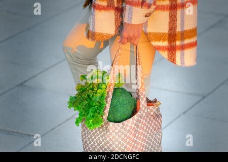 Woman with eco reusable textile grocery bag with vegetables. Healthy plant based diet. Zero waste, plastic free concept Stock Photo
