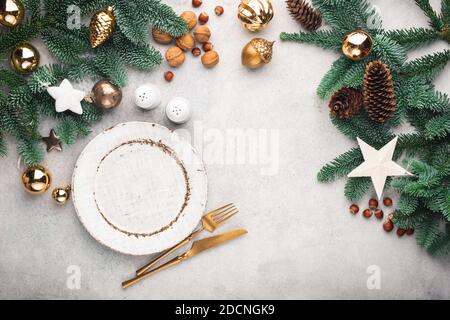 Christmas or New Year table setting mock up or frame with copy space for design elements and text. Top view. Empty plate, cutlery, fir tree and Christ Stock Photo