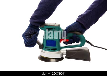 Man in protective blue gloves hold handles of eccentric orbital sander machine at isolated white background Stock Photo