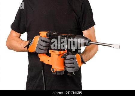 Male hands in protective gloves holding new big electric perforator with long drill and handle at isolated white background Stock Photo